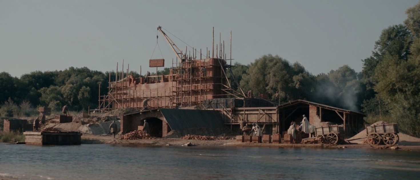 Budowa drewnianej warowni nad rzeką, rusztowania i wozy